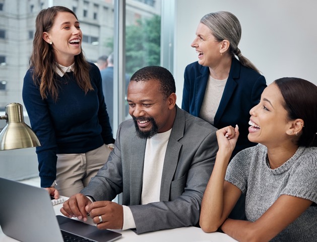 Shot of a group of businesspeople using a laptop at the office